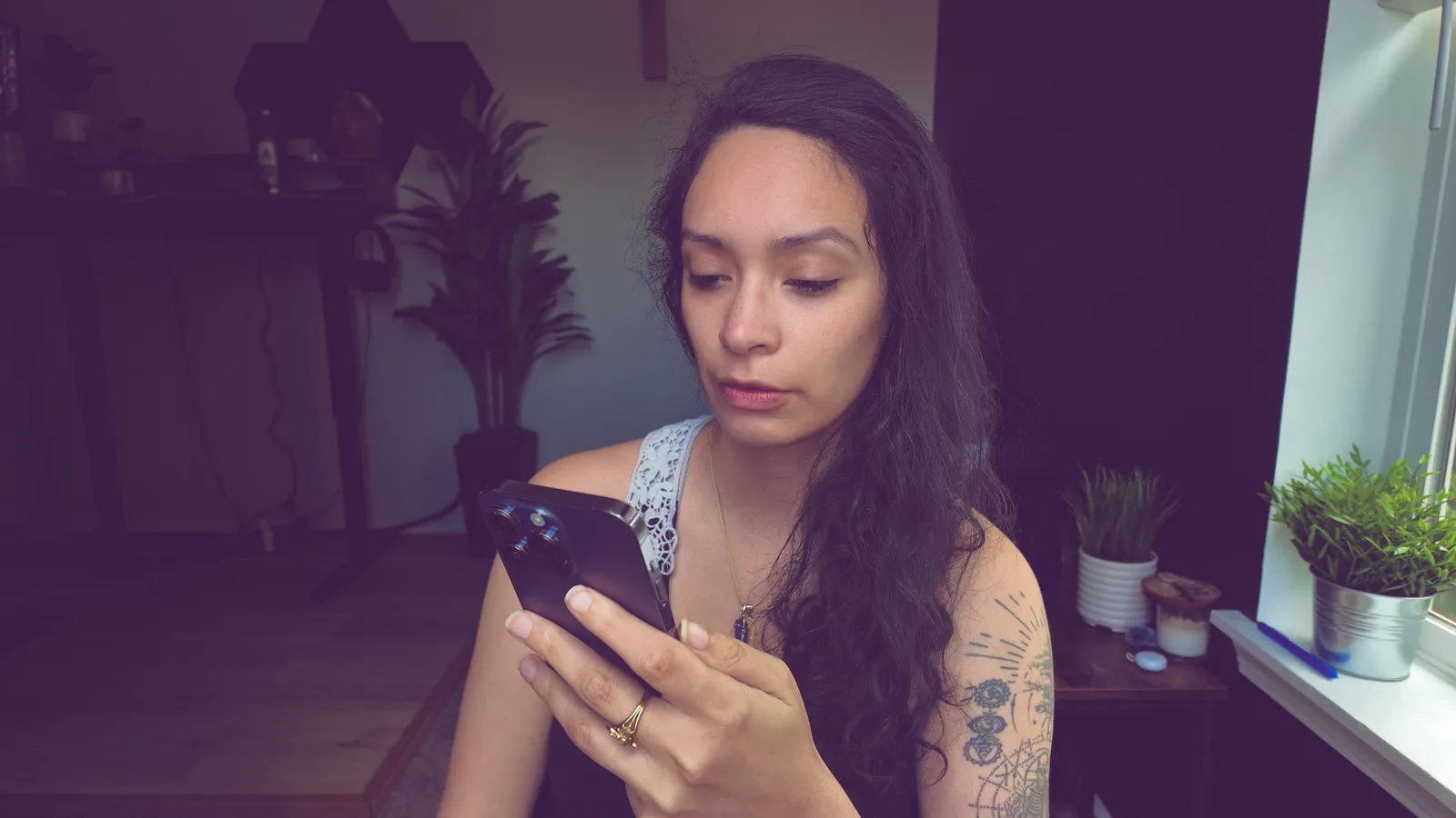 Mel checking her phone at her desk, surrounded by post analytics