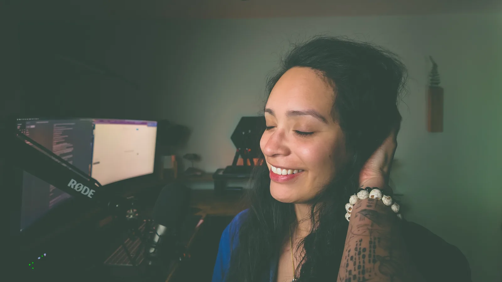 Mel laughing at her desk microphone mid-recording