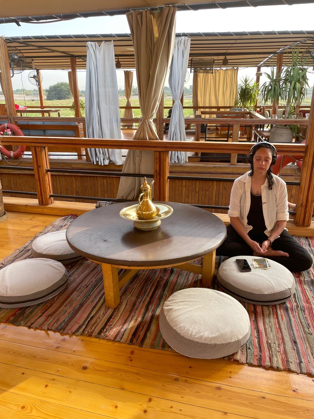 Mel Cobian meditating on cushions aboard a boat on the Nile