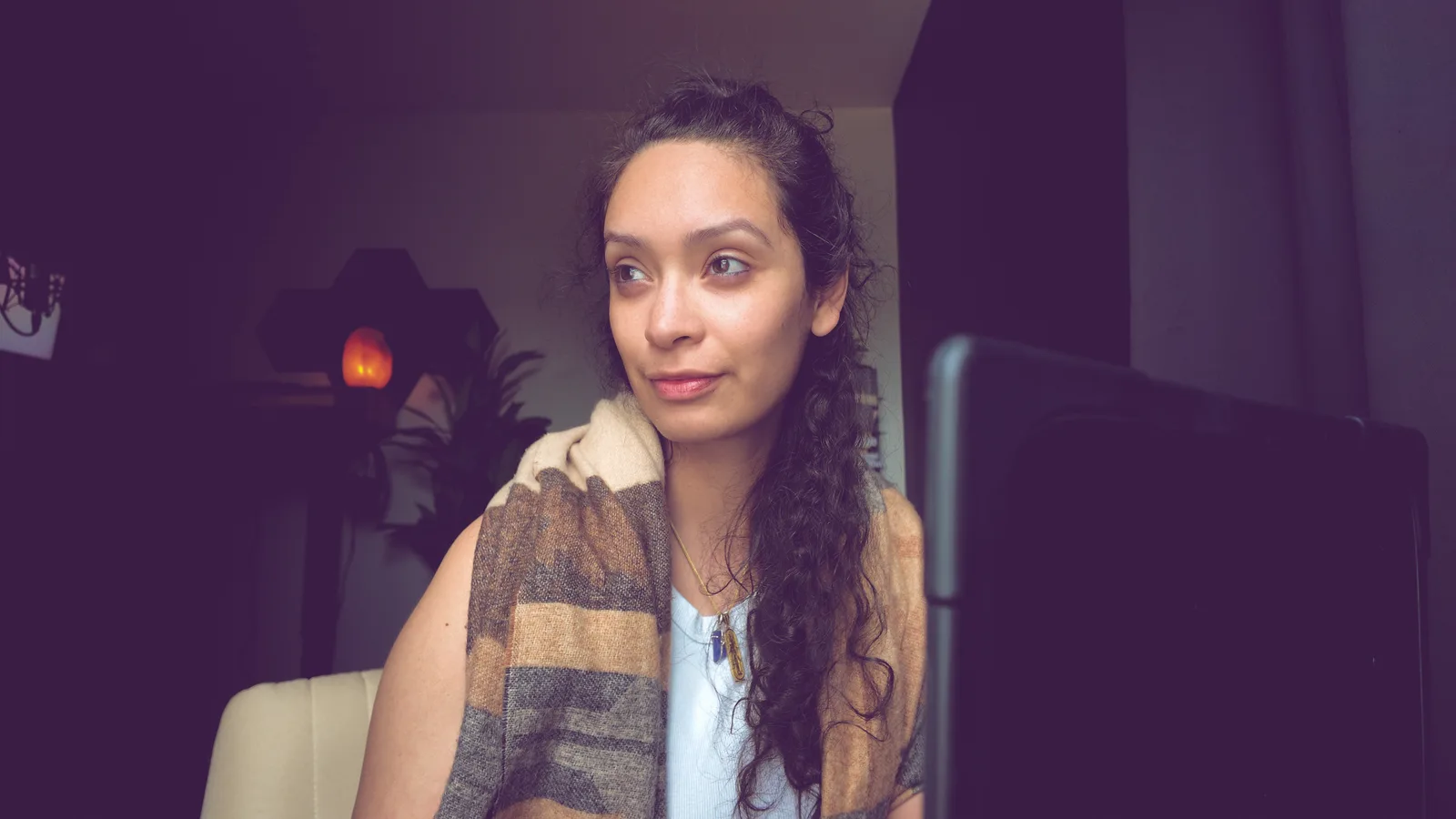 Mel Cobian at a desk wrapped in a woven shawl